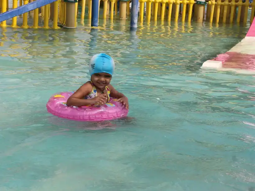 A grinning kid floating in an inflatable swim ring