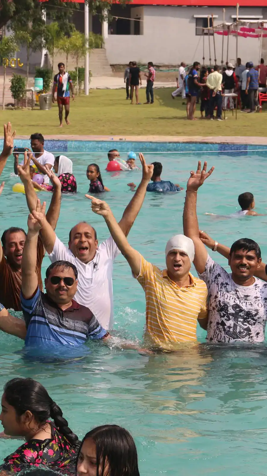 A family posing chest-deep in the pool, all grins